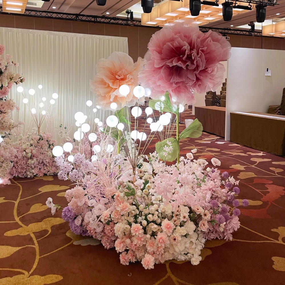 Our giant flowers paired with tall hedges and bubble lights are